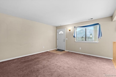 Carpeted entryway with baseboards