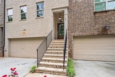 View of exterior entry featuring driveway, a garage, and brick siding