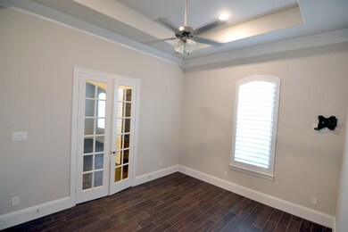 Study with French Doors, TRAY CEILING, Plank-Tile flooring that is throughout home, and Lovely window viewing Front Yard and Culdesac.  A TV- mount is also shown on wall, at right.