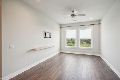 Spare room with dark wood finished floors, a ceil