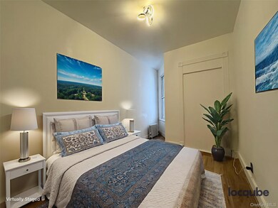 Bedroom with wood finished floors and radiator