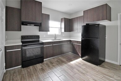 Kitchen with light hardwood / wood-style flooring, black appliances, dark brown cabinetry, and sink