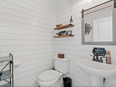 Bathroom featuring wooden walls, sink, and toilet