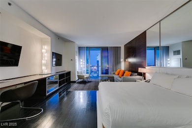 Bedroom with wood finished floors, a wall of windo