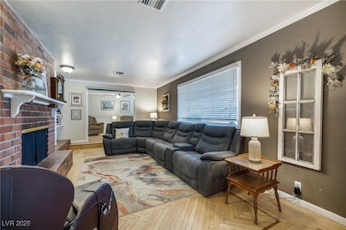 Living room with crown molding, a brick fireplace,