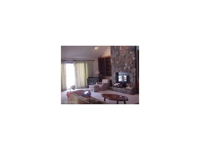 Two story Living room features stone fireplace sur