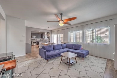 Living room with a ceiling fan and light wood-type flooring