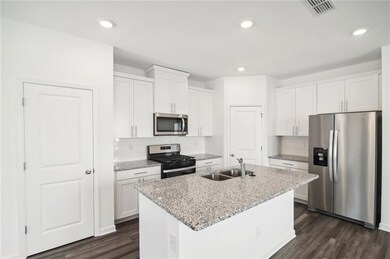 Kitchen with white cabinetry, sink, a kitchen isla