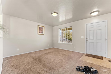Carpeted foyer entrance featuring baseboards