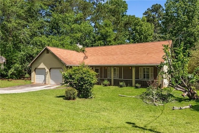 Ranch-style home with concrete driveway, a front yard, a garage, and a chimney