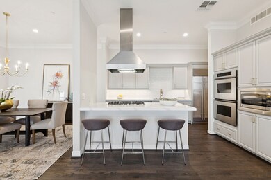 Kitchen with a peninsula, ornamental molding, backsplash, a breakfast bar, and white cabinetry