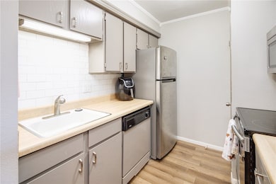 Kitchen with light wood-style flooring, a sink, ta
