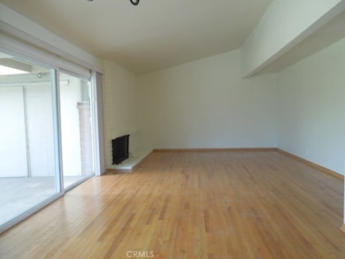 Large living room with a nice fireplace and beautiful wood floors. Newer sliding glass door.