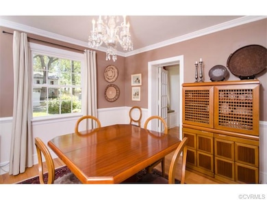 The dining room has hardwood, crown and a chair ra