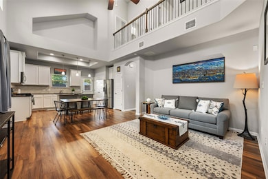 Living room with dark wood-type flooring, a high 
