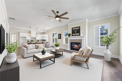 Living room with dark wood-style floors, ornamental molding, a fireplace, a chandelier, and healthy amount of natural light