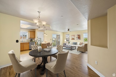 Dining space with a chandelier, light wood-style floors, and a textured ceiling
