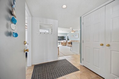 Entryway with a textured ceiling and light tile pa