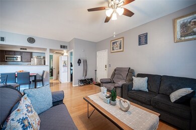 Living room with visible vents, ceiling fan, and l