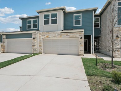 View of front facade featuring stone siding, a ga