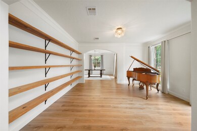 The entire home has been recently renovated.  New LVP flooring, and beautiful natural wood built-in bookshelves in this formal living room.  So spacious that there's still PLENTY of space even with this grand piano!!