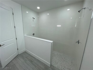 Bathroom with walk in shower and baseboards