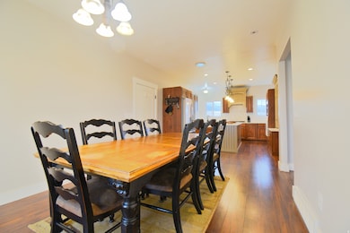 Dining area with a chandelier, dark wood finished floors, and recessed lighting