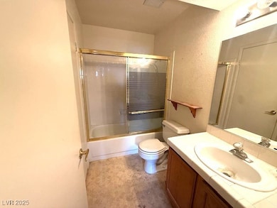 Bathroom featuring vanity, toilet, enclosed tub /