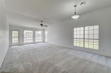 Spare room with lofted ceiling, a ceiling fan, vis