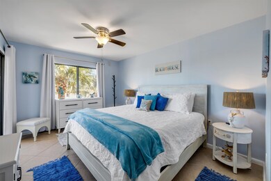 Tiled bedroom featuring a ceiling fan and baseboards