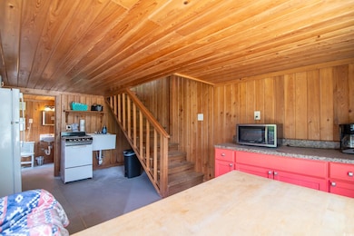 Kitchen featuring white appliances, wood ceiling, and wood walls