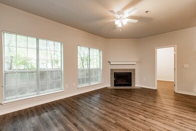Unfurnished living room with ceiling fan, dark wo