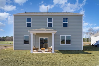 Rear view of property with a lawn and a patio area