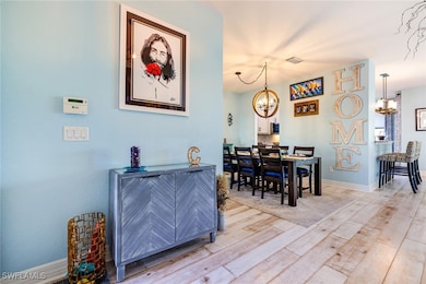Dining room with visible vents, baseboards, a chandelier, and light wood finished floors