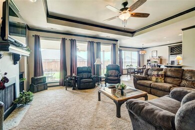Living room.  Fireplace, large windows, tray ceiling and crown molding.