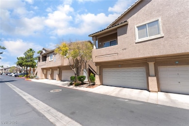 View of front of home with stucco siding, an attac