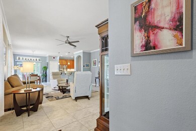 Living room featuring crown molding, light tile pa