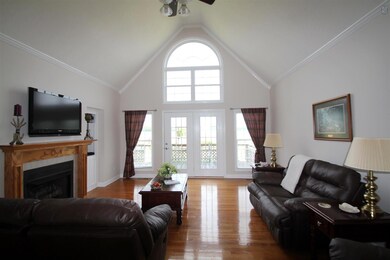 Hardwood floors and door leading to the deck in living room. 