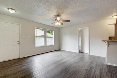 Unfurnished living room with ceiling fan, dark wo
