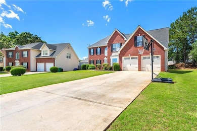 View of front of house featuring a garage, driveway, brick siding, and a front lawn