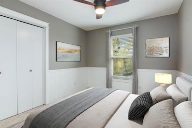 Bedroom with wainscoting, carpet floors, a closet