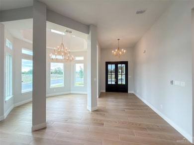 Foyer with french doors, wood tiled floors, and a chandelier