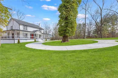 View of green lawn featuring covered porch