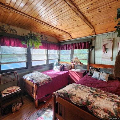 Bedroom with multiple windows, wood ceiling, wood finished floors, and lofted ceiling