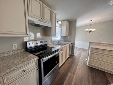 Kitchen with a notable chandelier, sink, appliance