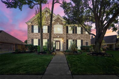Charming curb appeal showcases a lush, manicured lawn and mature trees, complemented by an automatic driveway gate that adds both elegance and privacy.