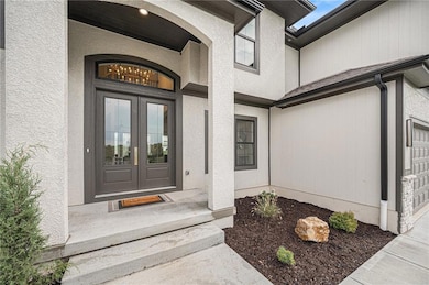 Entrance to property with a garage and french doors