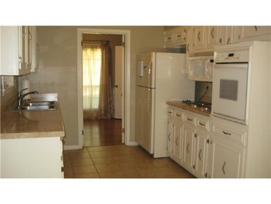 Kitchen has tiled floors, refrigerator stays.
