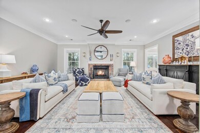 Living room with crown molding, ceiling fan, wood-