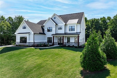 Modern inspired farmhouse featuring a front lawn a